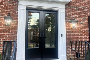 black double-door with white trim surrounded by brick